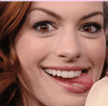 a close up of a woman 's face with her tongue hanging out .