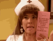 a woman in a nurse 's hat is holding a pink card .