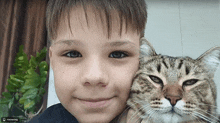 a young boy is holding a cat with a watermark that says moscowking