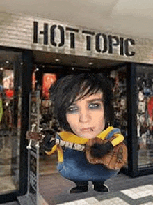 a person is standing in front of a hot topic store .