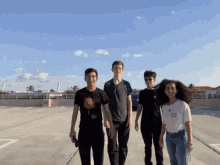 a group of young people standing in a parking lot with one wearing a shirt that says i love you