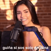 a woman is smiling in front of a microphone with the words guiana si sos solo de dana written on the bottom