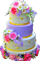 a three tiered cake decorated with pink and purple flowers and a gold ribbon