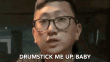 a man wearing glasses is saying `` drumstick me up baby '' .