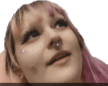 a girl with pink hair and freckles looks up at the camera