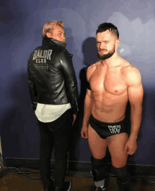 two men are standing next to each other one is wearing a balor club jacket