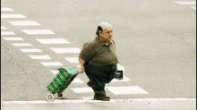 a fat man is pushing a shopping cart across a crosswalk .