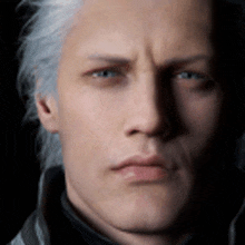 a man with gray hair and blue eyes is looking at the camera .