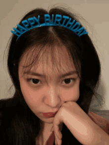 a girl wears a blue headband that says happy birthday