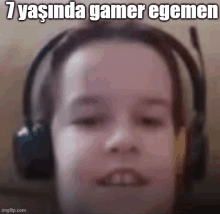 a close up of a person wearing headphones with the words `` 7 yasinda gamer egemen '' written on the bottom .