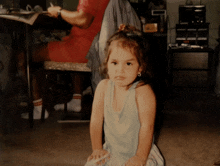 a little girl is sitting in front of a man sitting at a desk