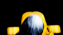 a blurry picture of a yellow object with a white face on a black background .