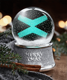 a snow globe that says merry xmas with a blue cross on it