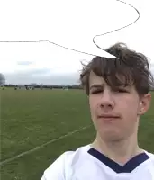 a boy in a white shirt with a blue collar is standing in a field