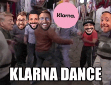 a group of men are dancing in front of a pink sign that says klarna dance