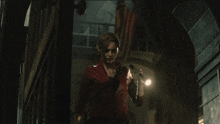 a woman in a red leather jacket is holding a flashlight in a dark room