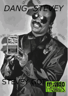 a black and white photo of stevie wonder holding a plaque