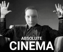 a black and white photo of a man with his hands in the air and the caption absolute cinema