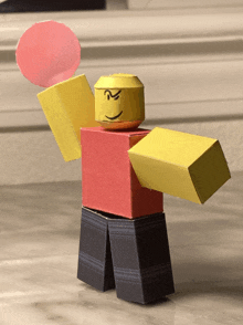 a toy roblox character with a red shirt and yellow arm