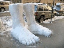 a pair of feet made out of snow are sitting on the sidewalk