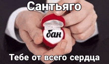 a person is holding a heart shaped ring in their hands with russian writing on it