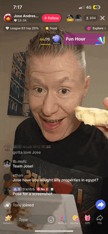 a man holding a piece of food in front of a screen that says fun hour