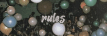 a bunch of balloons are floating in the air with the words `` rules '' written on the bottom .