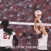 two women are playing volleyball on a court and one of them is holding a volleyball in her hand .