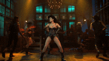 a woman in a cowboy hat is dancing in a room with other people