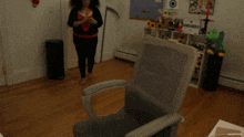 a woman standing next to a chair in a room with a sign that says minecraft on it