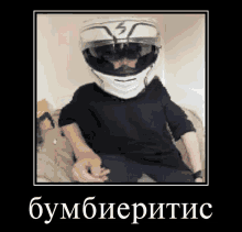 a man wearing a motorcycle helmet and sunglasses is sitting on a couch .