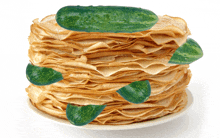 a stack of pancakes with green cucumbers on top of them