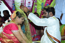 a bride and groom are covered in yellow powder during their wedding ceremony