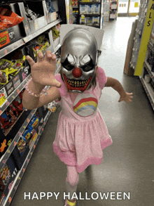 a little girl wearing a clown mask in a store with the words happy halloween below her