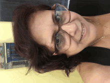 a woman wearing glasses is smiling in front of a book store that says livres