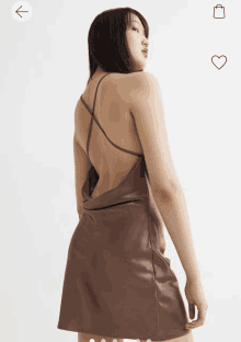 a woman is wearing a brown dress with a crisscross back