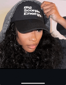 a woman is wearing a black hat that says big scorpio energy