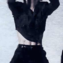 a man in a black shirt and black pants is dancing on a stage with his shirt off .