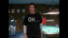 a man in a black shirt is standing in front of a pool table with the words `` oh ... '' written on his shirt .