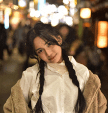 a woman with braids and a white shirt is smiling