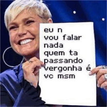 a woman is holding a sign that says eu n vou falar nada