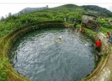 a group of people are playing in a large circular pool of water