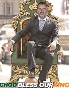 a man in a suit and tie is sitting on a throne with the words ghod bless our king on the bottom