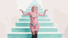 a woman in a pink cat dress is dancing on a set of stairs .