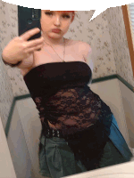 a woman in a black lace top takes a selfie in a bathroom mirror