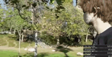 a man in a black shirt is standing in a park with trees in the background and a sign that says for the cuffs