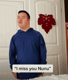 a man in a blue shirt says " i miss you nunu " in front of a red leaf