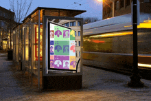 a bus stop with a poster on it that says ' i am a woman '