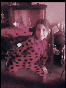 a little girl in a ladybug costume stands in a room