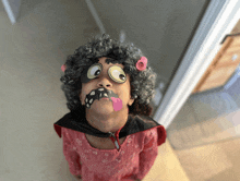 a little girl wearing a wig and makeup looks up at something